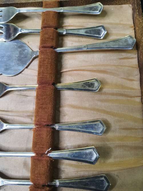 AN ANTIQUE DESERT CAKE SERVING SET IN ITS ORIGINAL BROWM CASE SOLD AS IS