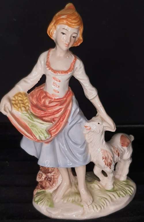 A FARM GIRL WITH HER DOG CARRYING FLOWER PORCELAIN FIGURINE SOLD AS IS