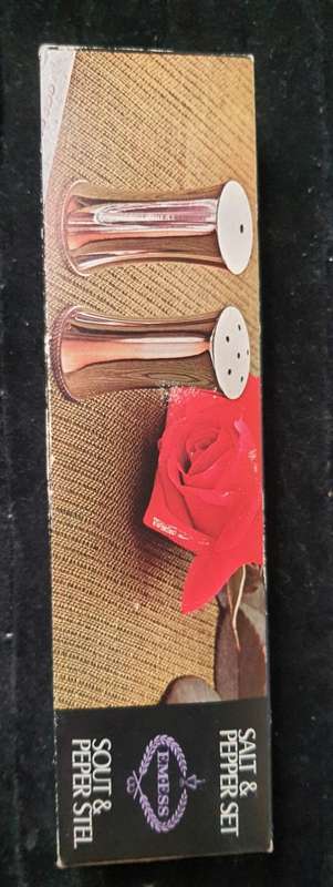 A VINTAGE SET OF SALT AND PEPPER SHAKERS IN ITS ORIGINAL PACKAGING SOLD AS IS