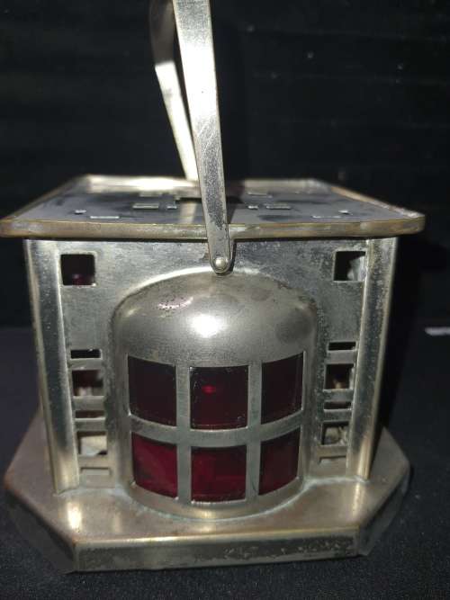 AN ANTIQUE  STAINLESS STEEL LANTETRN WITH A RED GLASS INSERT SOLD AS IS
