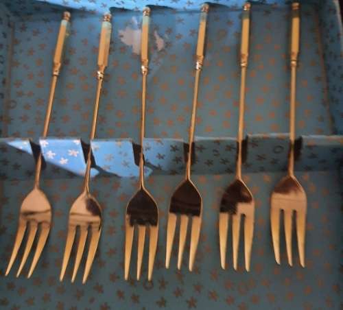 A COMPLETE SET GOLD PLATED COCKTAIL FORKS SOLD AS IS