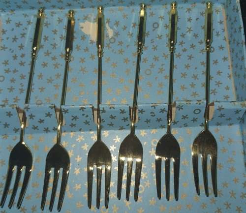 A COMPLETE SET GOLD PLATED COCKTAIL FORKS SOLD AS IS