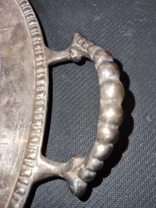 AN ANTIQUE SILVER-PLATED SOLID SERVING TRAY SOLD AS IS