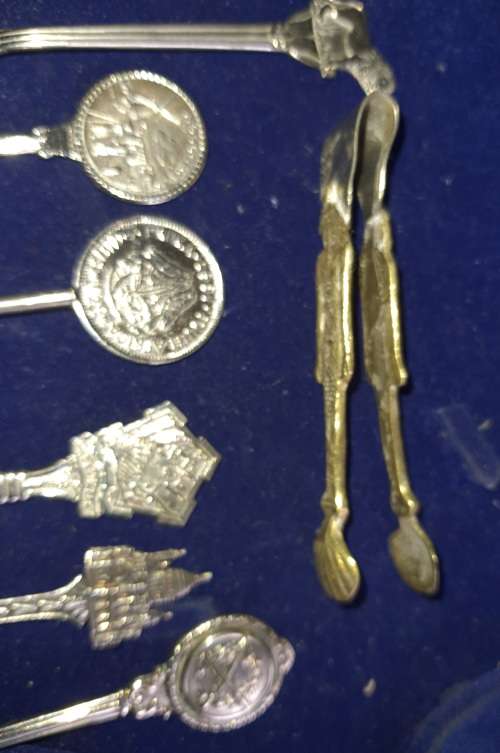A VINTAGE COLLECTION OF MEMROBILIA TEASPOONS AND A TONG FROM VARIUOS COUNTRIES