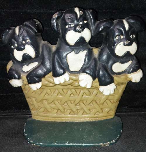 A heavy cast iron metal three puppies in a basket door stopper made in China sold as is