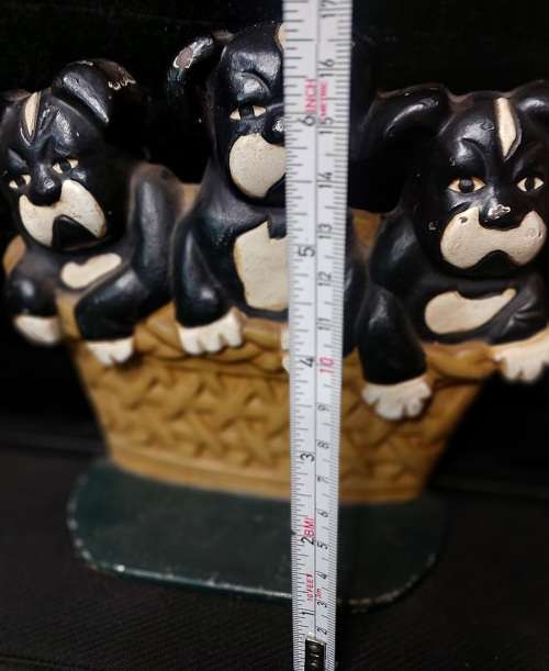 A heavy cast iron metal three puppies in a basket door stopper made in China sold as is