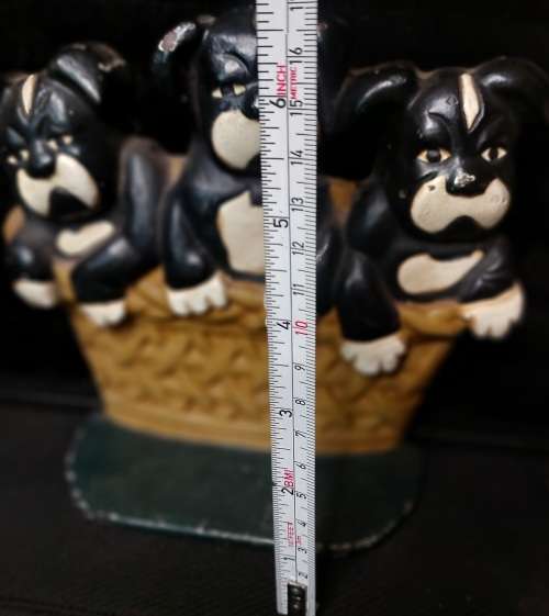 A heavy cast iron metal three puppies in a basket door stopper made in China sold as is