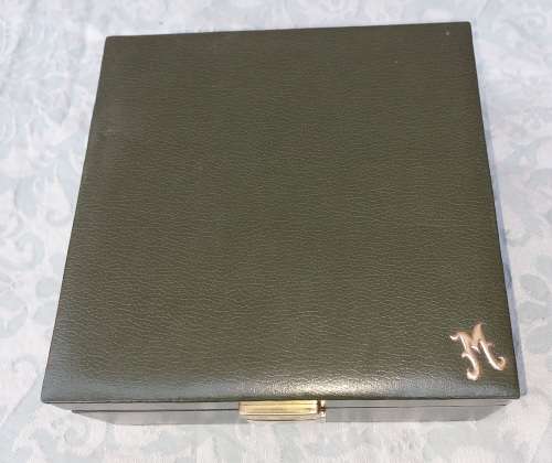 A VINTAGE GREEN LEATHER WITH A GOLD PLATED LETTER M JEWELRY BOX SOLD AS IS