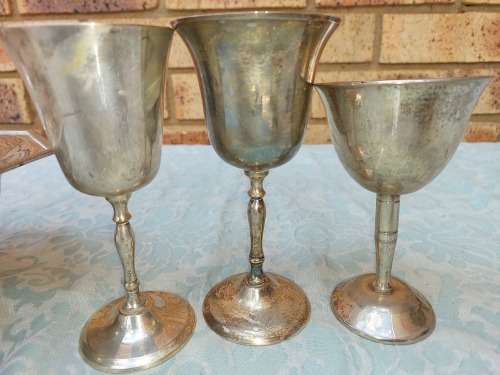 A MIXED VINTAGE JOB LOT WINE FLUTES AND A SERVING BOWL ALL SILVER PLATED SOLD AS IS