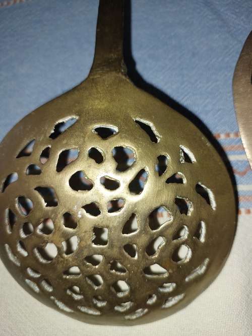 A SET OF ORNAMENTAL BRASS LADEL AND FORK MADE IN ISREAL LENGTH 35 TO 40 CENTIMETERS SOLD AS IS