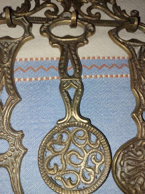 A SET OF 4 BRASS KITCHEN ORNAMENTAL CUTLERY MADE IN ISREAL SOLD AS IS