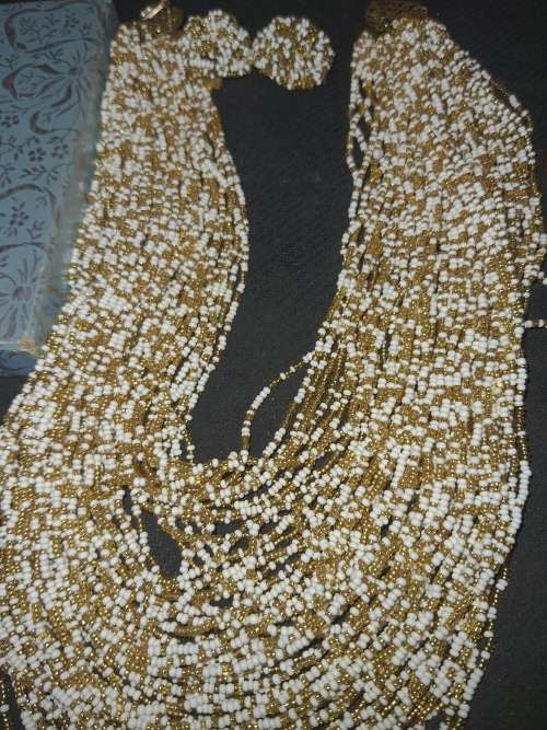 A COLLECTION OF MULTI-STRAND GOLD AND WHITE BEADED NECKLACE WITH MATCHING EARRINGS