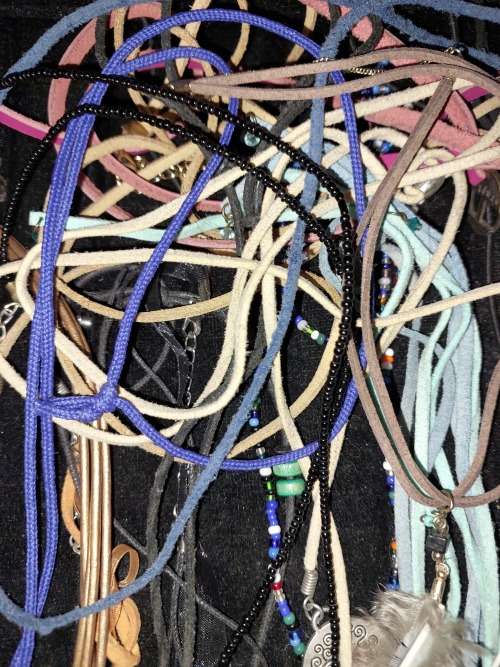 A BULK COLLECTION OF LEATHER ROPE COSTUME NECKLACES SOLD AS IS