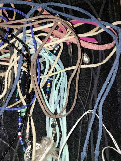 A BULK COLLECTION OF LEATHER ROPE COSTUME NECKLACES SOLD AS IS