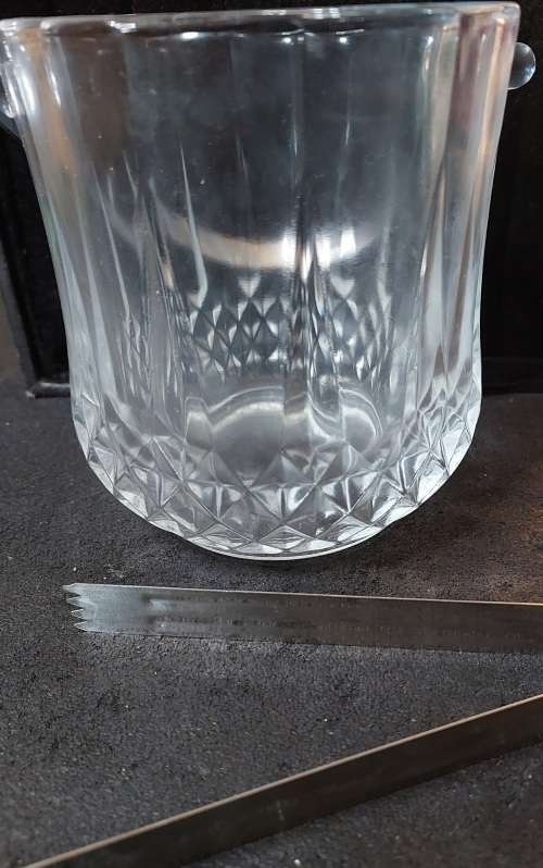 A FANCY CRYSTAL GLASS TYPE ICE BUCKET AND TONGS SOLD AS IS