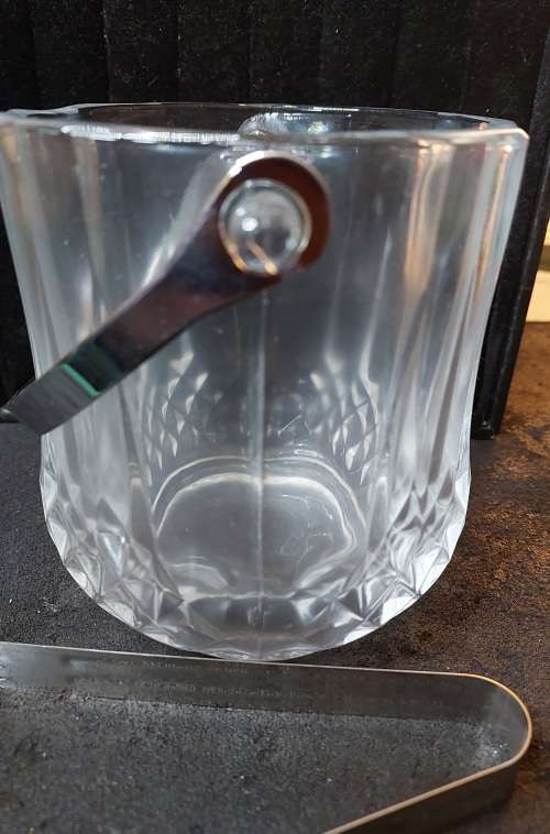 A FANCY CRYSTAL GLASS TYPE ICE BUCKET AND TONGS SOLD AS IS