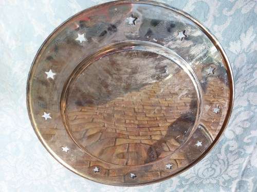 A  ROUND STAINLESS STEEL SERVING TRAY WITH STARS PUNCHED AROUND THE BRIM SOLD AS IS