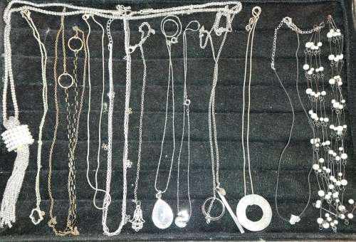 A COLLECTION OF SILVER PLATED AND STAINLESS STEEL NECKLACES WITH PENDANTS SOLD AS IS