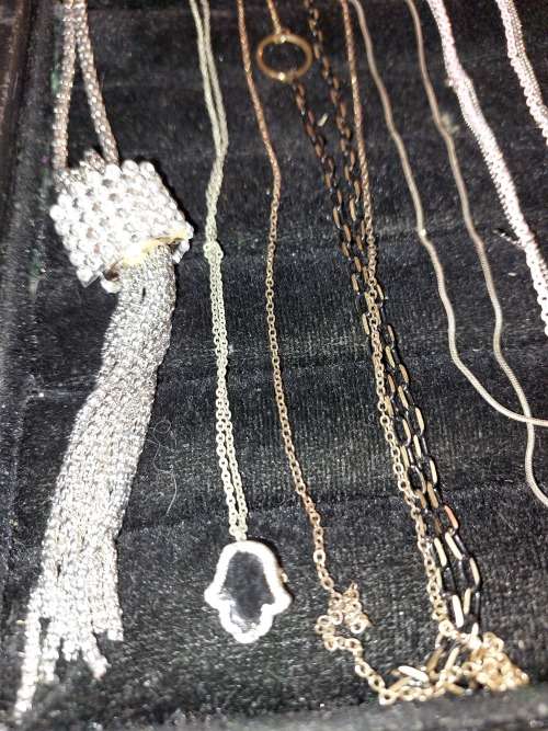 A COLLECTION OF SILVER PLATED AND STAINLESS STEEL NECKLACES WITH PENDANTS SOLD AS IS