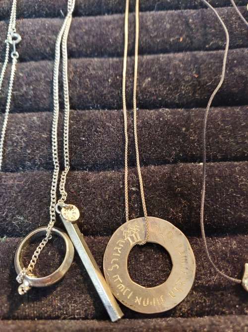 A COLLECTION OF SILVER PLATED AND STAINLESS STEEL NECKLACES WITH PENDANTS SOLD AS IS