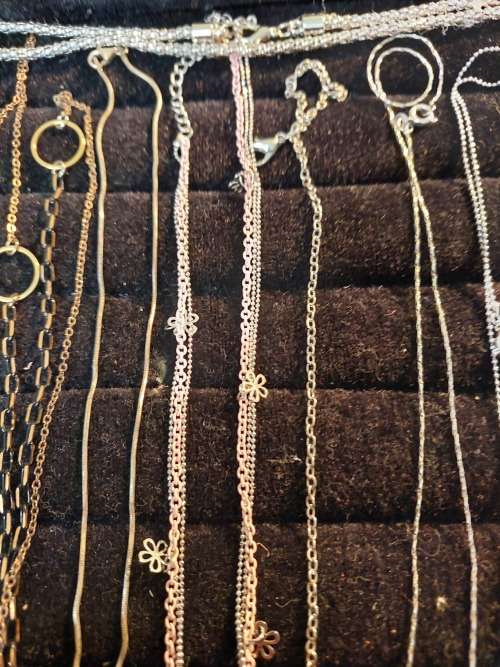 A COLLECTION OF SILVER PLATED AND STAINLESS STEEL NECKLACES WITH PENDANTS SOLD AS IS