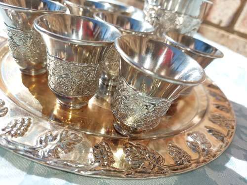 A VINTAGE KIDDUSH SET OF CUPS AND SERVING TRAY SOLD AS IS