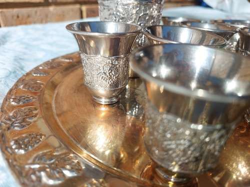 A VINTAGE KIDDUSH SET OF CUPS AND SERVING TRAY SOLD AS IS