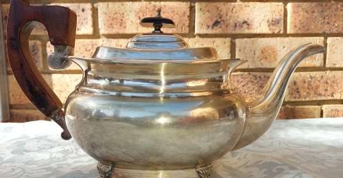 AN ANTIQUE EPNS SHEFFIELD TEAPOT WITH A TEAK HANDLE