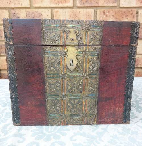 AN ANTIQUE WOODEN CHEST WITH INTRICATE BRONZE WORK