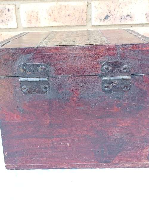 AN ANTIQUE WOODEN CHEST WITH INTRICATE BRONZE WORK