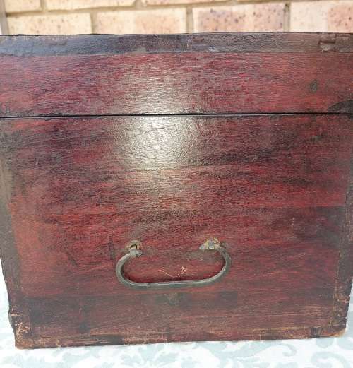 AN ANTIQUE WOODEN CHEST WITH INTRICATE BRONZE WORK