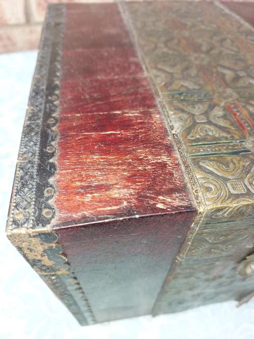 AN ANTIQUE WOODEN CHEST WITH INTRICATE BRONZE WORK