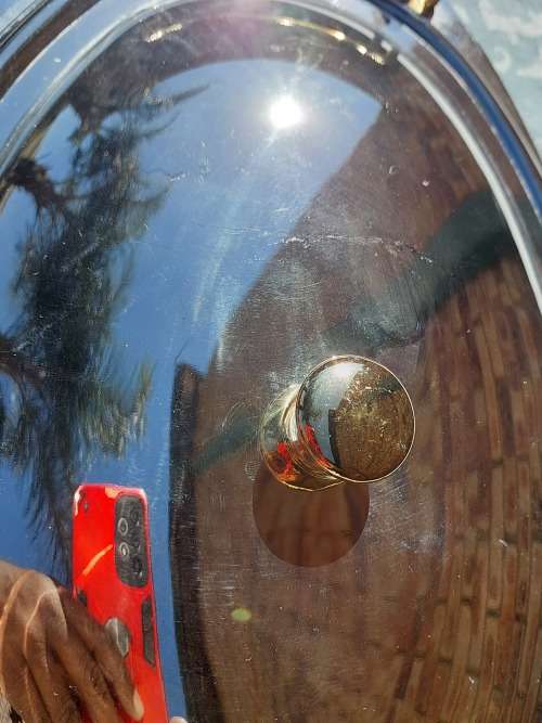 AN OVAL STAINLESS STEEL SERVING PLATTER WITH GOLD TONE HANDLES SOLD AS IS