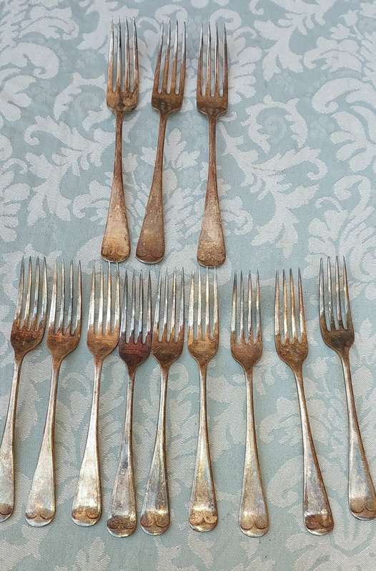 AN ANTIQUE SET OF TABLE FORKS SOLD AS IS