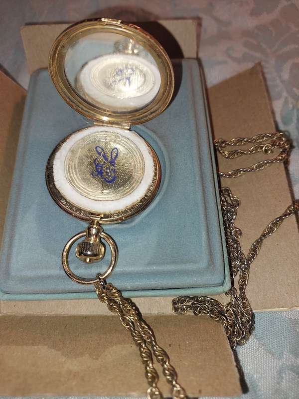 AN ANTIQUE ESTEE LAUDER FILIGREE WATCH STYLE COMPACT GOLD PLATED  WITH CHAIN