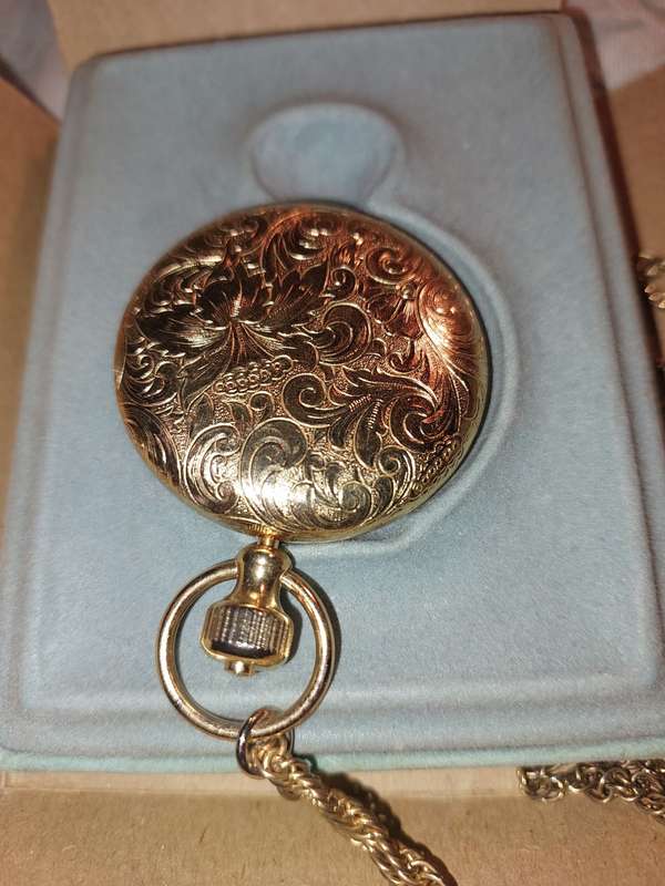 AN ANTIQUE ESTEE LAUDER FILIGREE WATCH STYLE COMPACT GOLD PLATED  WITH CHAIN