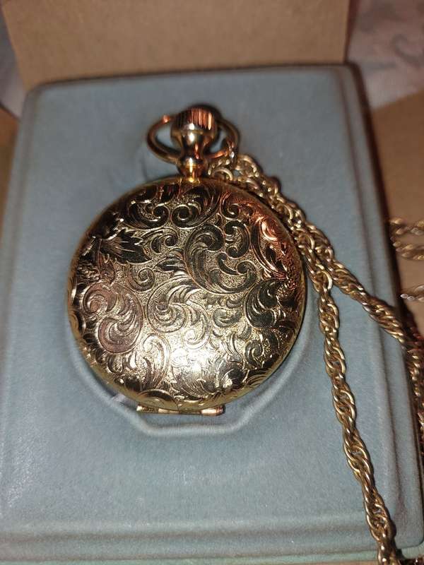 AN ANTIQUE ESTEE LAUDER FILIGREE WATCH STYLE COMPACT GOLD PLATED  WITH CHAIN