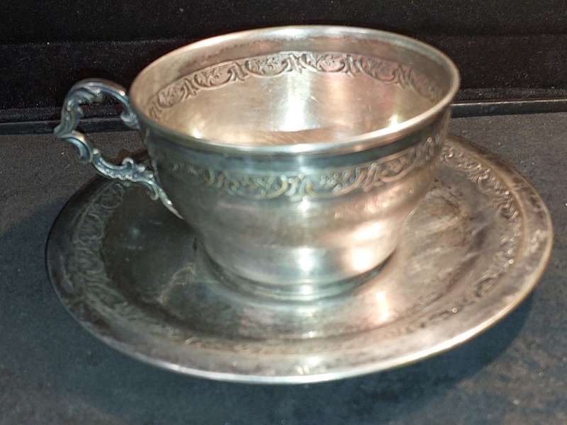 A VINTAGE SILVER PLATED TEA CUP AND SAUCER