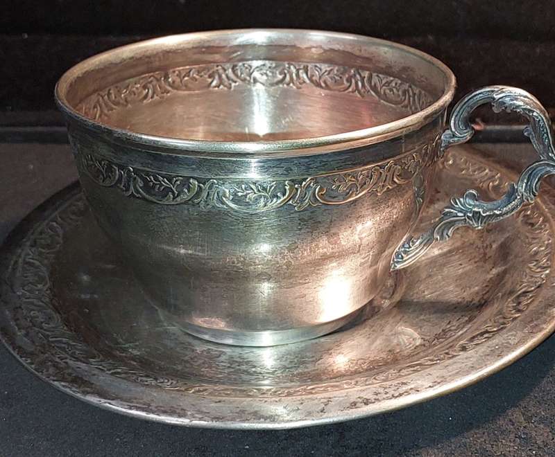 A VINTAGE SILVER PLATED TEA CUP AND SAUCER
