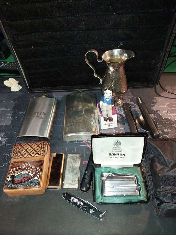A COLLECTION OF FLASKS CIGARETTE LIGHTERS  POCKET KNIVES AND A LEATHER CIGARETTE HOLDER SOLD AS IS