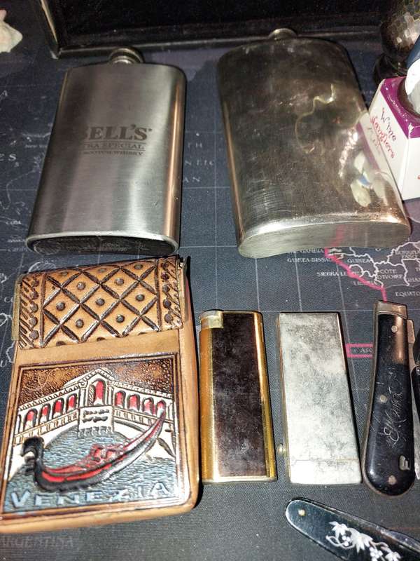 A COLLECTION OF FLASKS CIGARETTE LIGHTERS  POCKET KNIVES AND A LEATHER CIGARETTE HOLDER SOLD AS IS