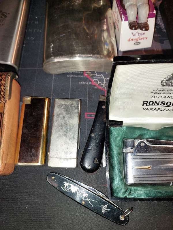 A COLLECTION OF FLASKS CIGARETTE LIGHTERS  POCKET KNIVES AND A LEATHER CIGARETTE HOLDER SOLD AS IS