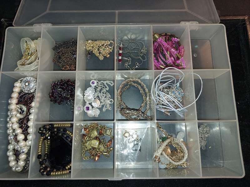 A BULK COLLECTION OF COSTUME JEWELRY AND THE PLASTIC CASES SOLD AS IS