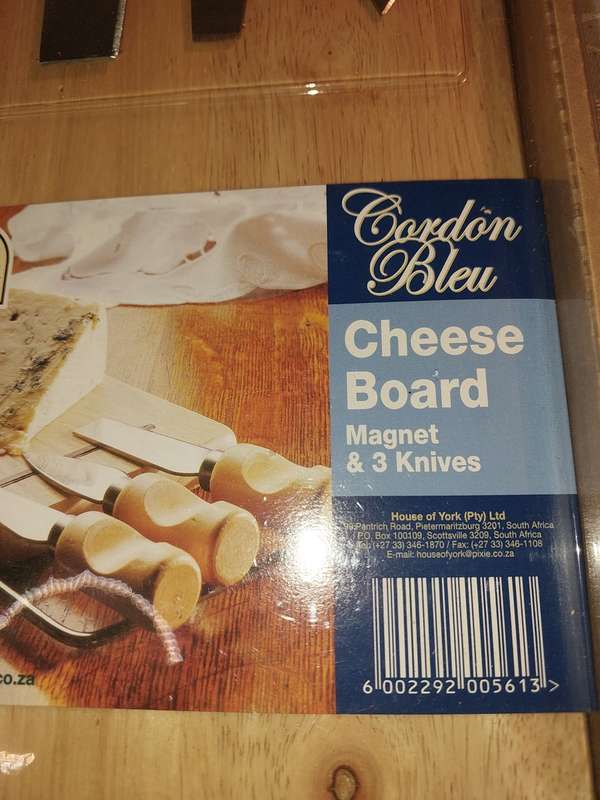 A NEVER BEEN USED GORDON BLU CHEESE BOARD AND THREE KNIVES SOLD AS IS