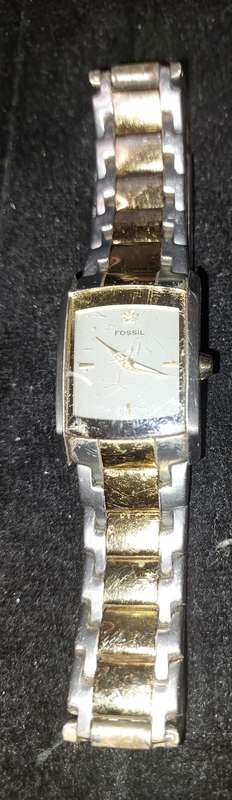 A VINTAGE WOMAN FOSSIL STEEL AND GOLD RECTANGULAR WATCH