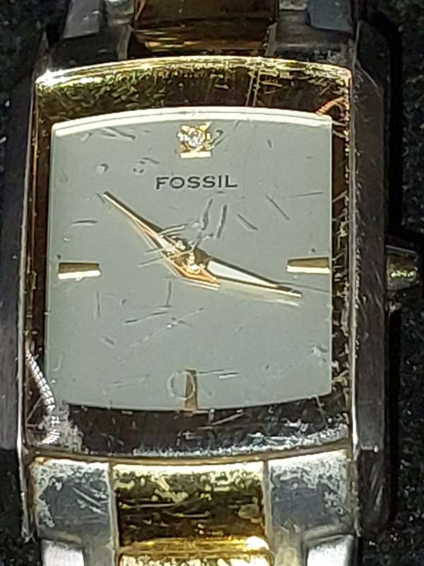 A VINTAGE WOMAN FOSSIL STEEL AND GOLD RECTANGULAR WATCH