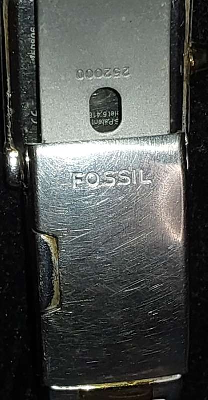 A VINTAGE WOMAN FOSSIL STEEL AND GOLD RECTANGULAR WATCH