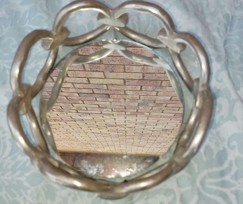 A ROUND CHAIN LINK STYLE ART DECOR SERVING TARY WITH A MIRROR BASE,