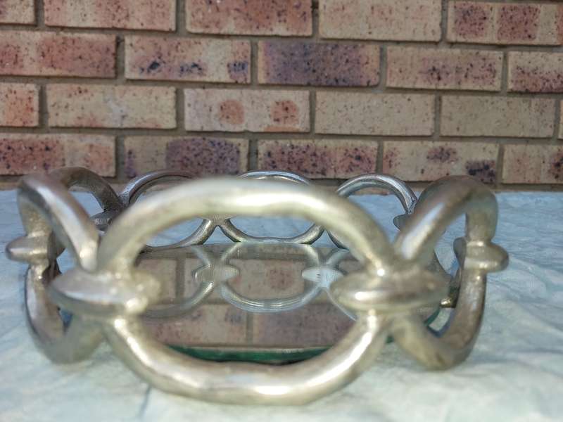 A ROUND CHAIN LINK STYLE ART DECOR SERVING TARY WITH A MIRROR BASE,