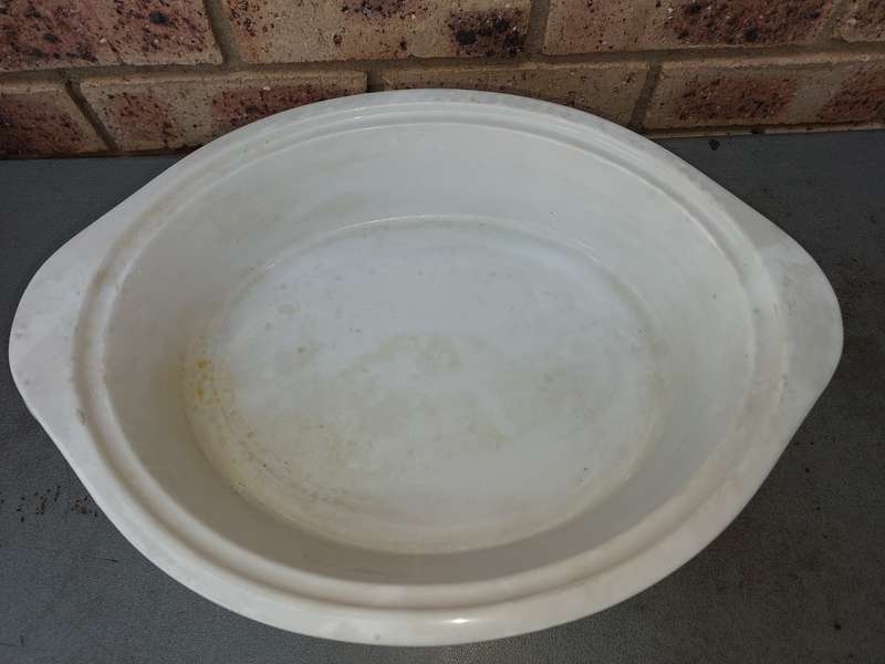 AN OVEN PROOF PORCELAIN CASSEROLE BOWL WITH A STAINLESS STEEL CANDLE STAND WARMER